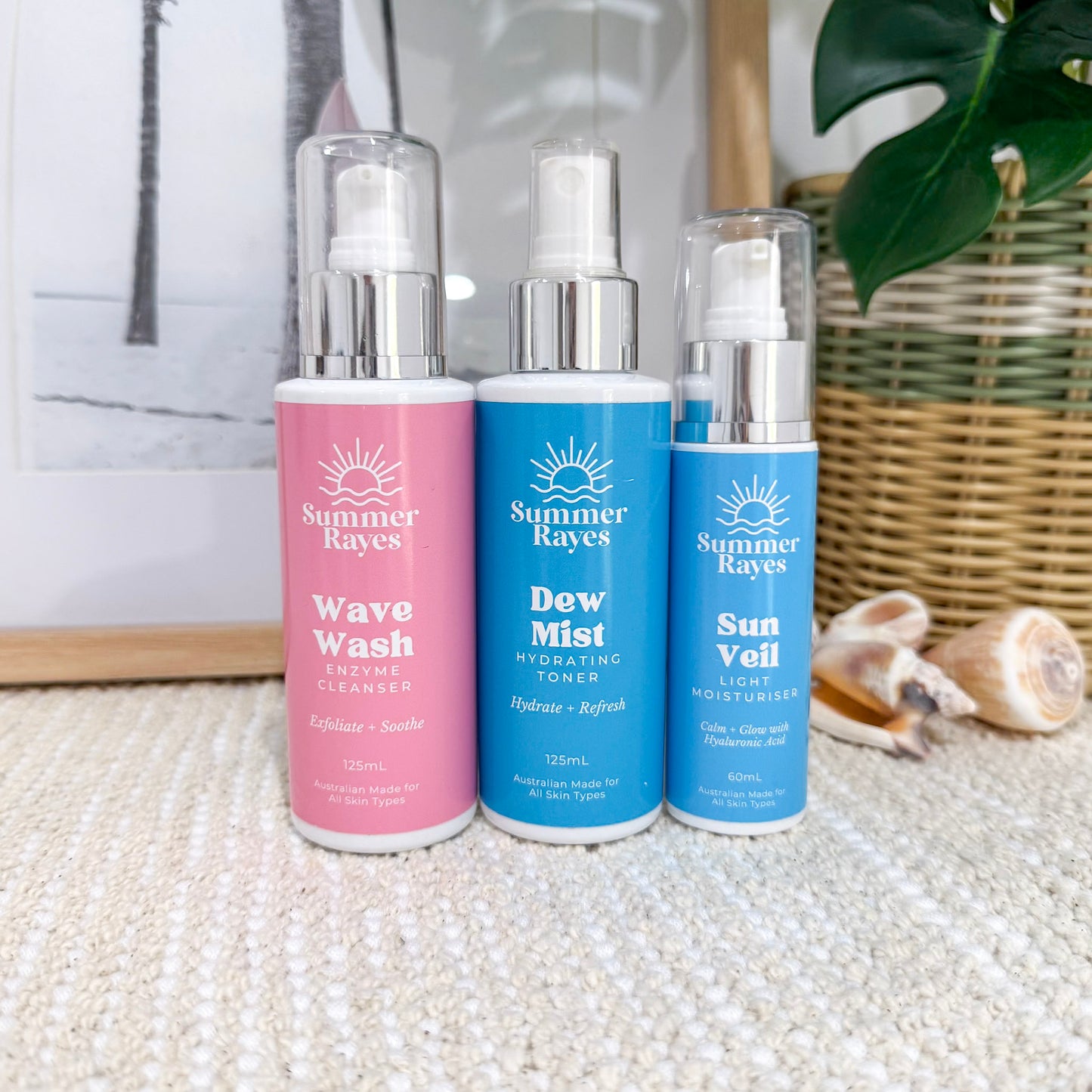 Three bottles of Summer Rayes skincare products on a textured surface with a neutral background.