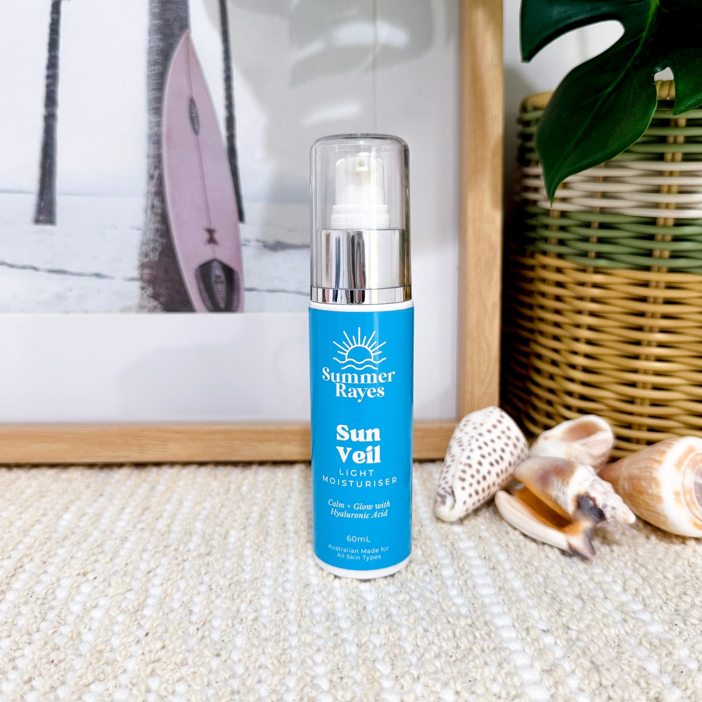 Summer Rayes Sun Veil moisturizer bottle on a textured surface with decorative elements