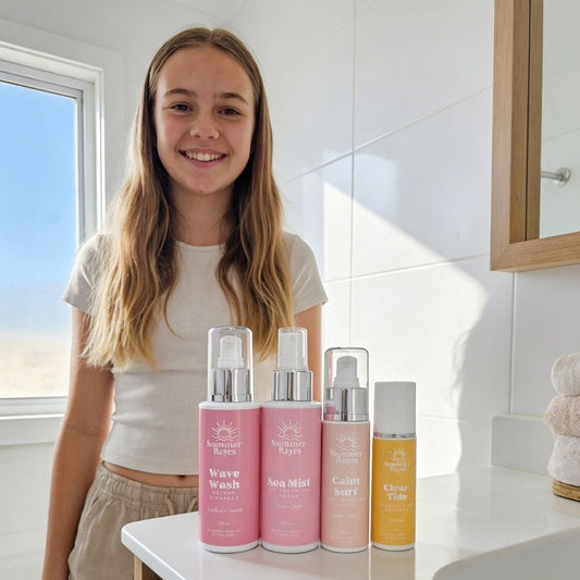 Young girl standing in a bathroom with teen skincare products on a counter.