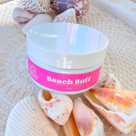 Jar of teen skincare 'Beach Buff' scrub and mask surrounded by seashells on a textured surface