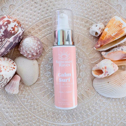 Pink bottle of teen skincare labeled 'Calm Surf' surrounded by seashells on a textured surface