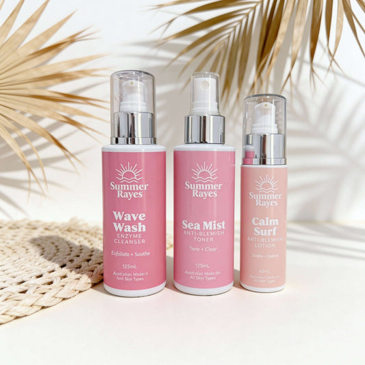 Three bottles of Summer Rayes skincare products on a light background with palm leaves.