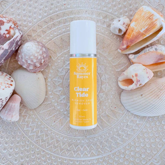 Bottle of 'Clear Tide' teen skincare product by Summer rayes on a textured surface with seashells.