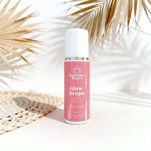 Summer Rayes Glow Drops Vitamin B Serum bottle on a light background with palm leaves