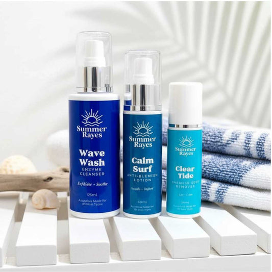 Three Summer Rayes teen boy skincare products on a white surface with a towel and shell in the background.