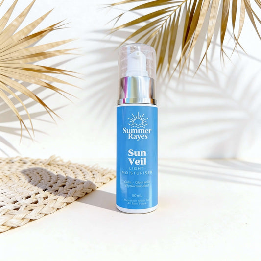 Summer Rayes Sun Veil bottle with palm leaves and woven mat in the background