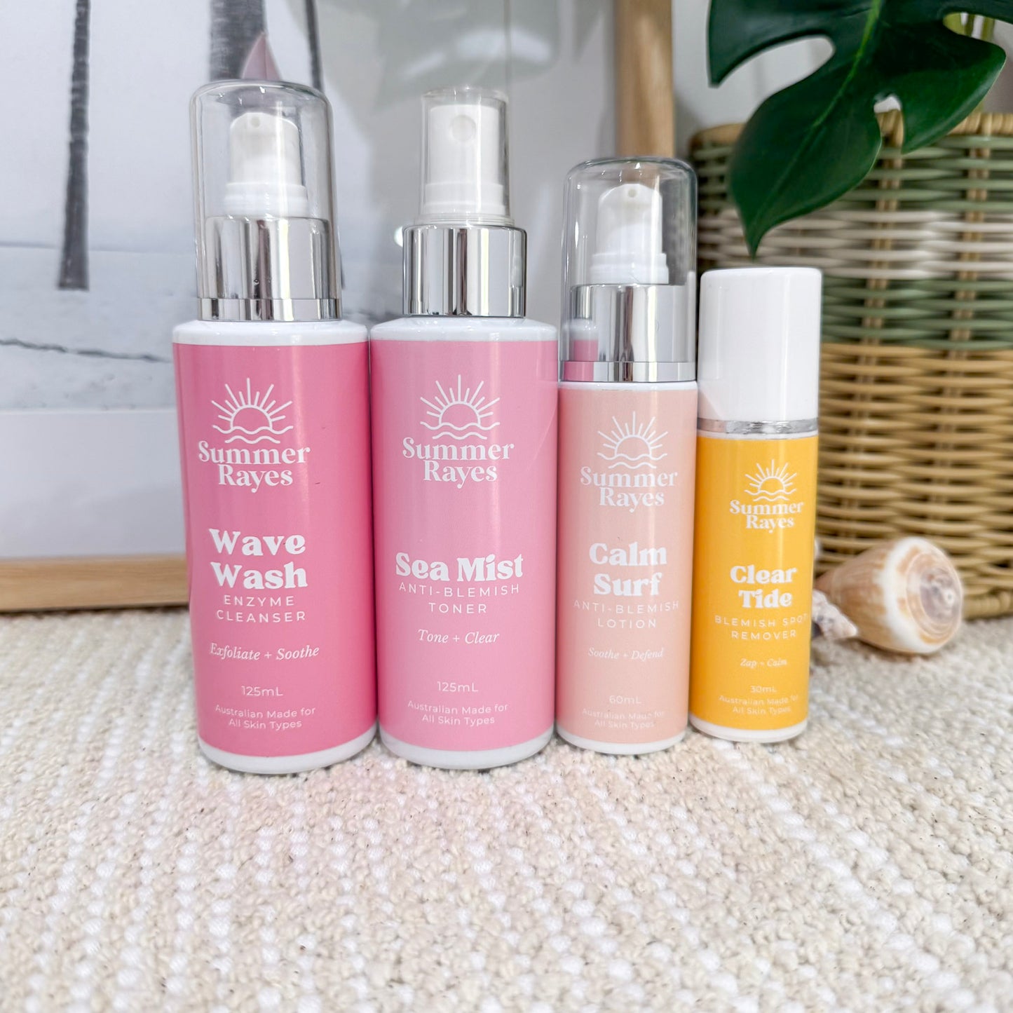 Four Summer Rayes skincare products on a textured surface with a blurred background