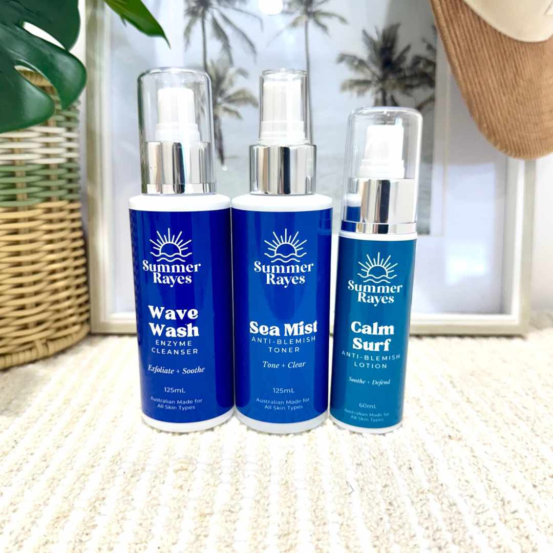 Three Summer Rayes skincare products on a textured surface with a blurred indoor background.