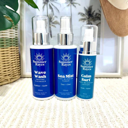 Three Summer Rayes skincare products on a textured surface with a blurred indoor background.