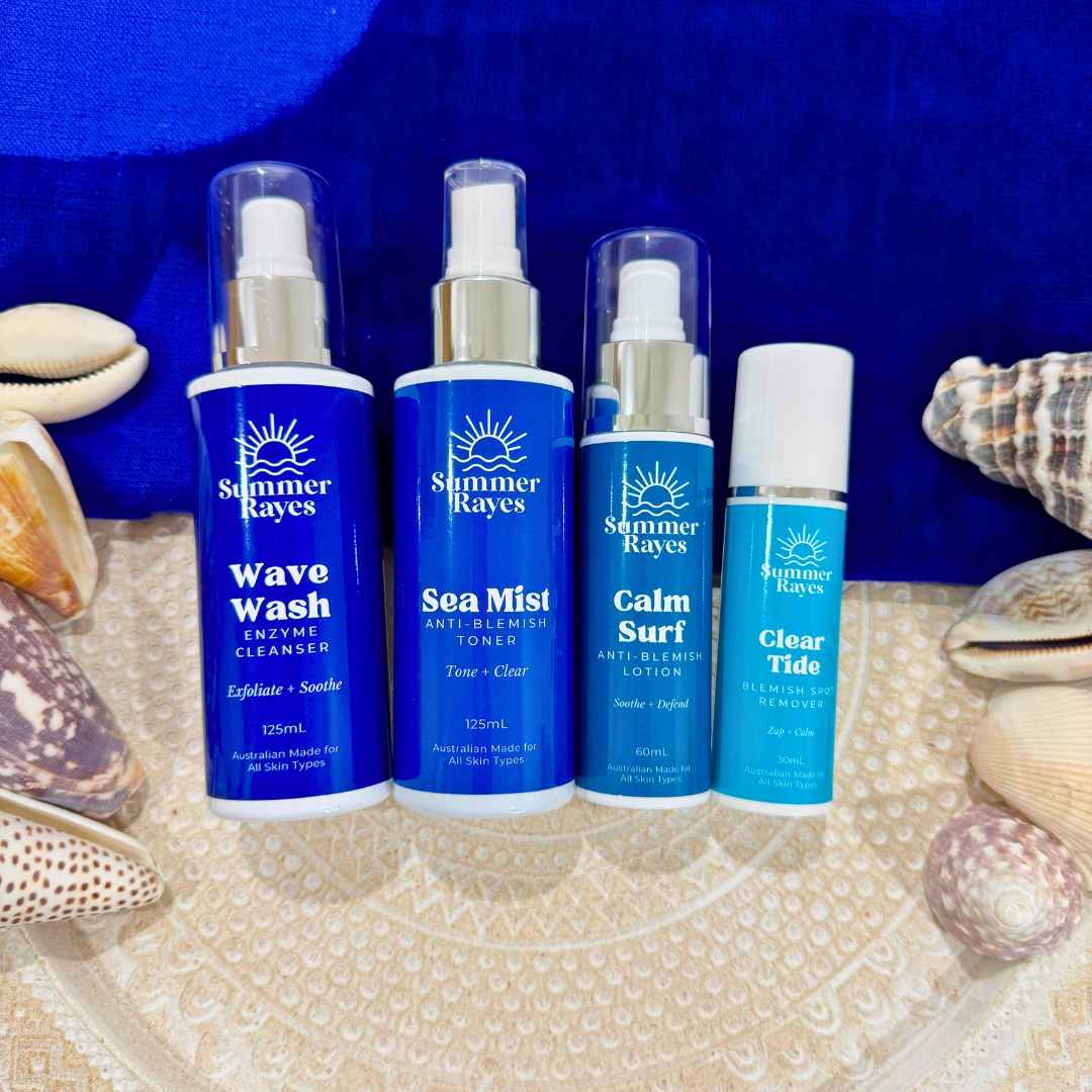 Four Summer Rayes skincare products on a beach setting with shells.