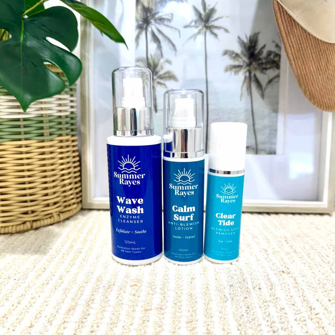 Three Summer Rayes skincare products on a textured surface with a blurred background