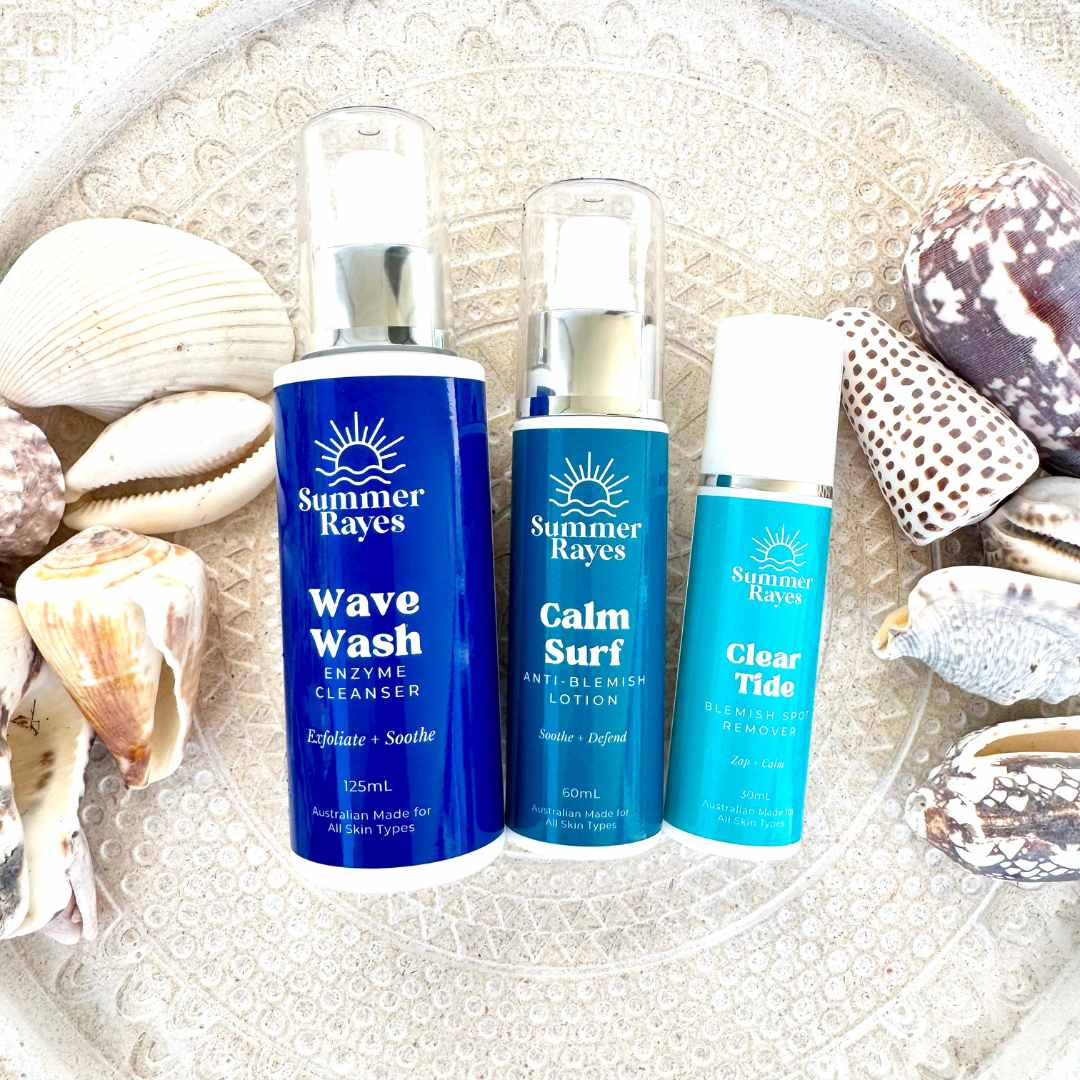 Three Summer Rayes skincare products on a textured surface with shells.