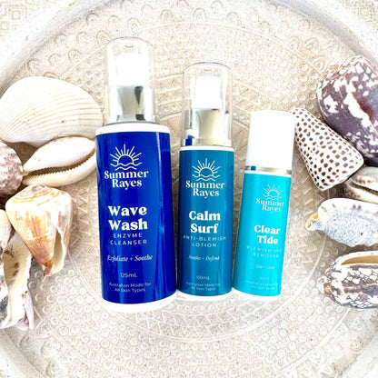 Three Summer Rayes skincare products on a textured surface with shells.